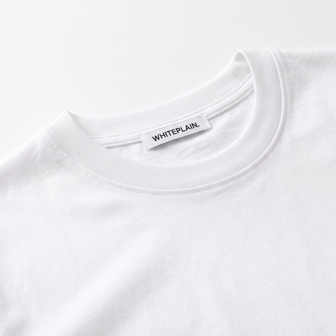 Collar close-up with the WHITEPLAIN label